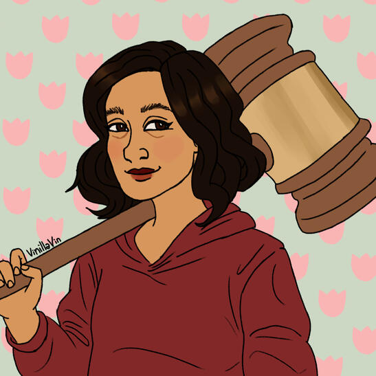 Quill's cartoon avatar. She has short brown hair, wears a dark red hoodie, and is holding a judge's gavel over her shoulder.